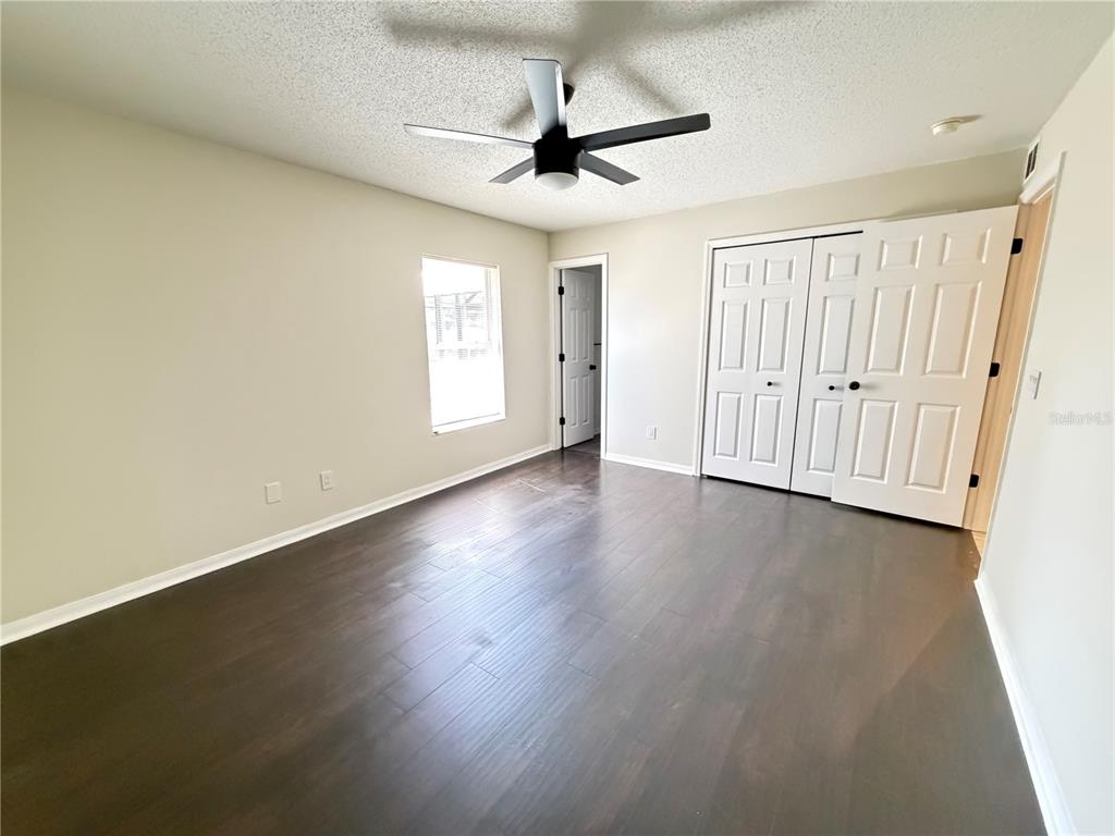 16 Powder Hill Lane Palm Coast, FL 32164 - Photo 7 of 27 an empty room with wooden floor ceiling fan and windows