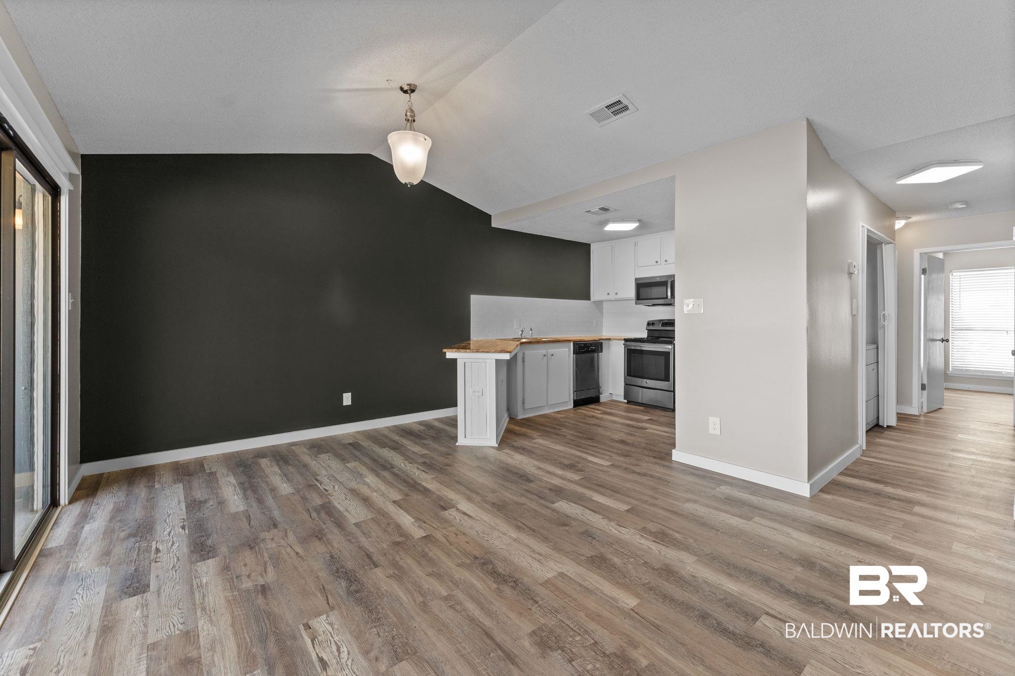 128 West Satsuma Avenue, Unit 128 Foley, AL 36535 - Photo 7 of 41 Kitchen with a peninsula, white cabinetry, stainless steel appliances, butcher block countertops, and light wood-type flooring