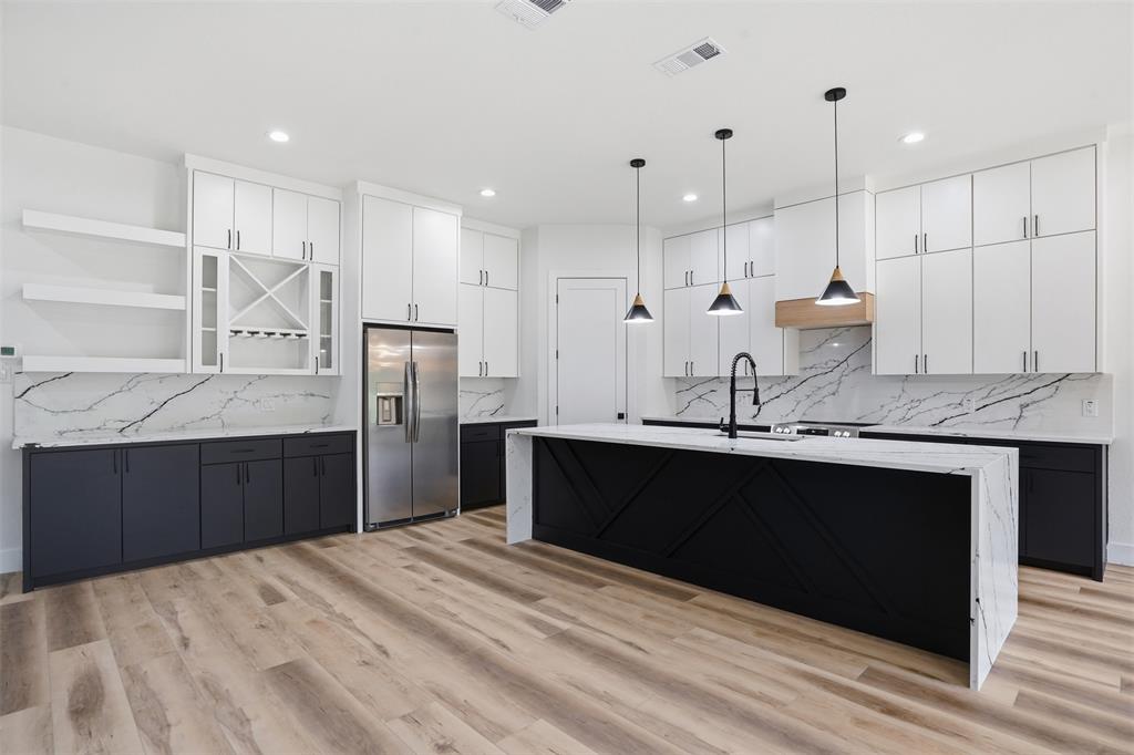1111 Riverwood Road Dallas, TX 75217 - Photo 17 of 40 Contemporary kitchen featuring a large central island with waterfall-edge countertop