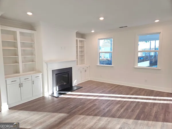 an empty room with windows and fireplace