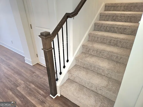a view of staircase with white walls and railing