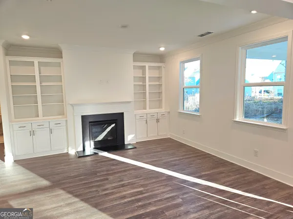 an empty room with windows and fireplace