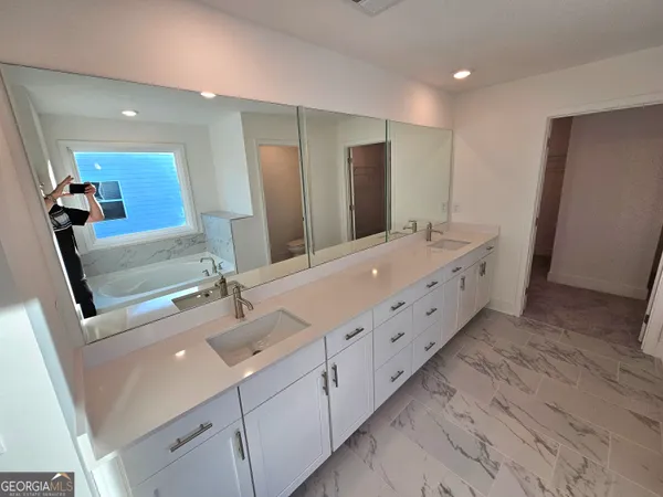 a bathroom with double vanity sink and mirror