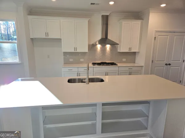 a kitchen with kitchen island a stove a sink and a refrigerator