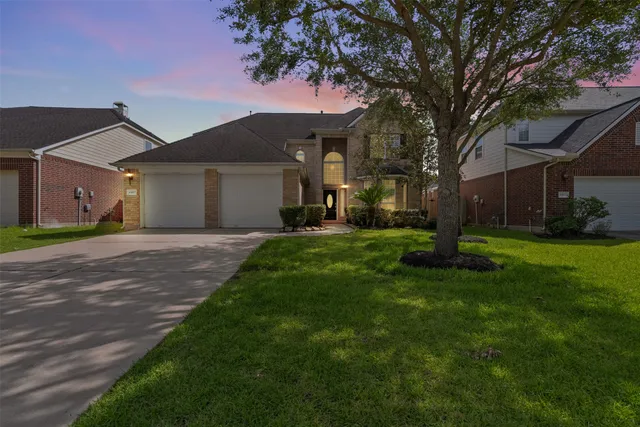 a front view of a house with a yard and trees