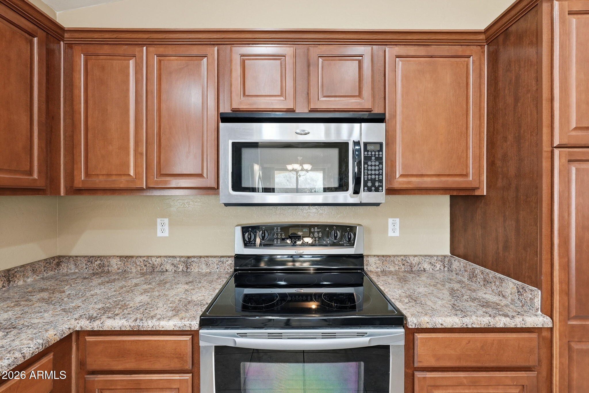2936 East Crescent Way Gilbert, AZ 85298 - Photo 22 of 40 a kitchen with granite countertop wood cabinets and stainless steel appliances