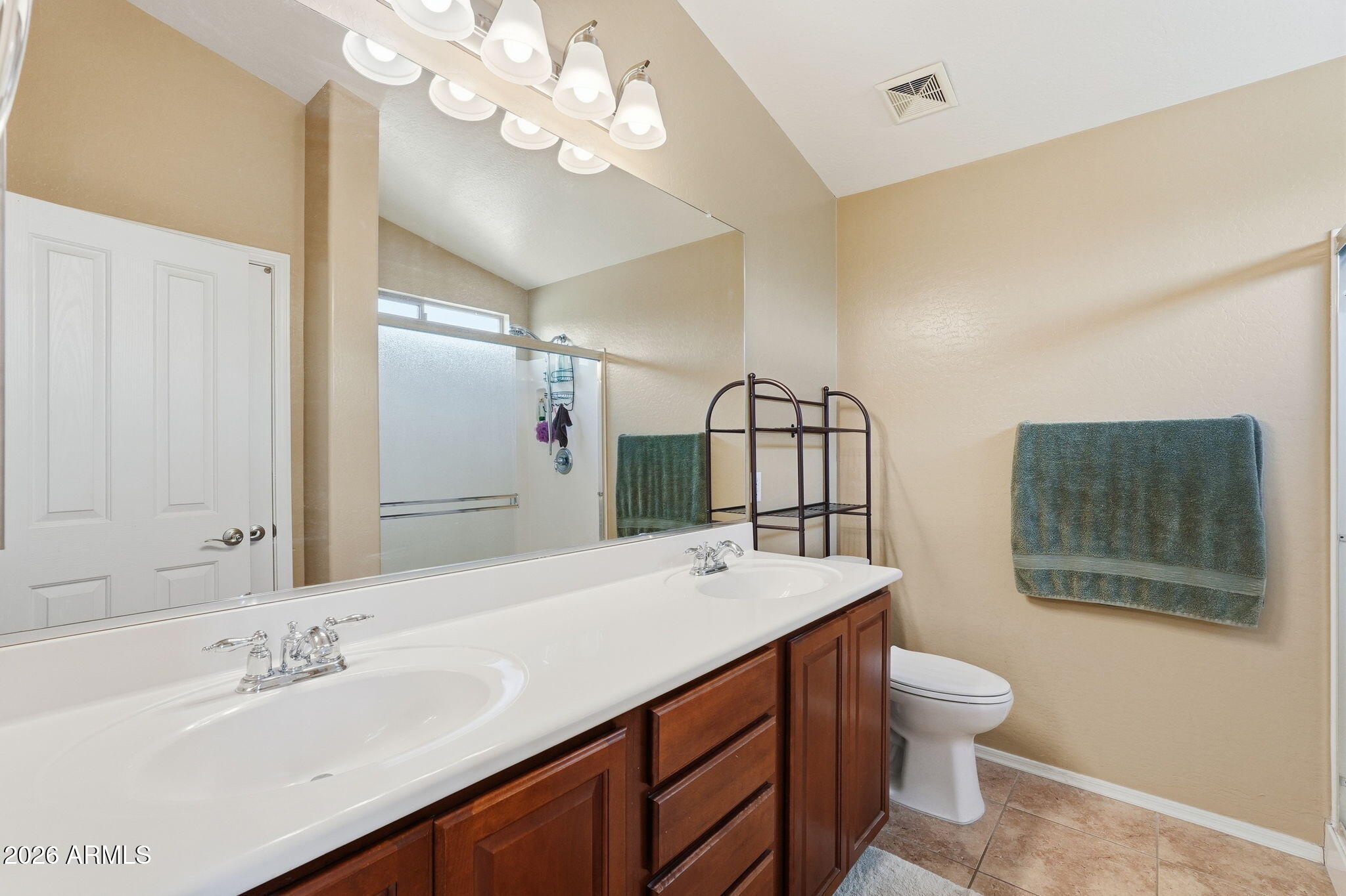 2936 East Crescent Way Gilbert, AZ 85298 - Photo 7 of 40 a bathroom with a toilet a sink a mirror and a shower