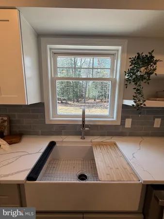 a spacious bathroom with a granite countertop sink a toilet a mirror and shower