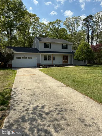 a front view of a house with a yard and trees