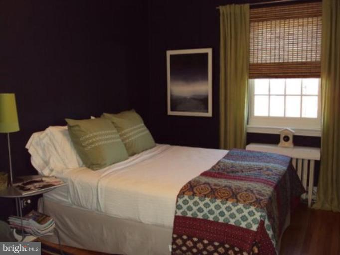 3721 Rexmere Road Baltimore, MD 21218 - Photo 14 of 18 a bedroom with a bed and wooden floor