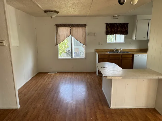 a kitchen with a wooden floor and a window