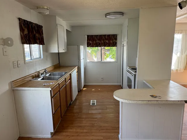 a kitchen with granite countertop a sink stove and refrigerator