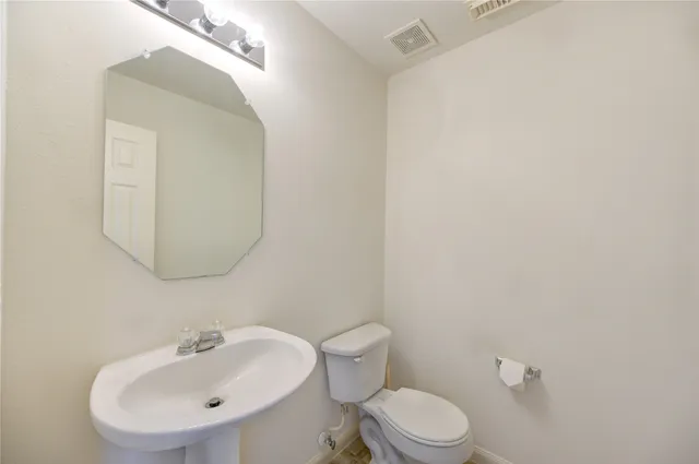 a bathroom with a sink mirror and toilet