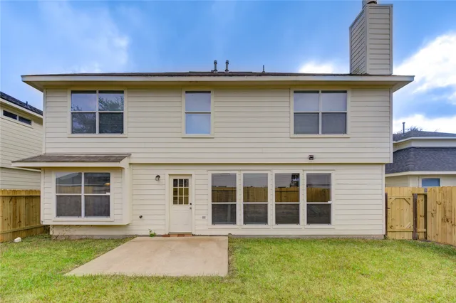a view of backyard of house with wooden fence