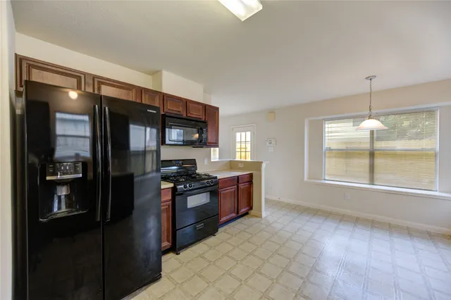 a kitchen with stainless steel appliances granite countertop a refrigerator and a stove top oven