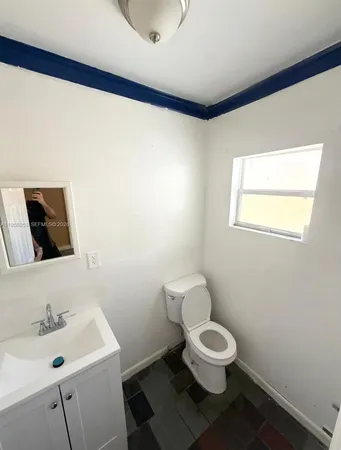 a bathroom with a toilet a sink and a mirror