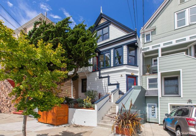 a front view of a house with a tree