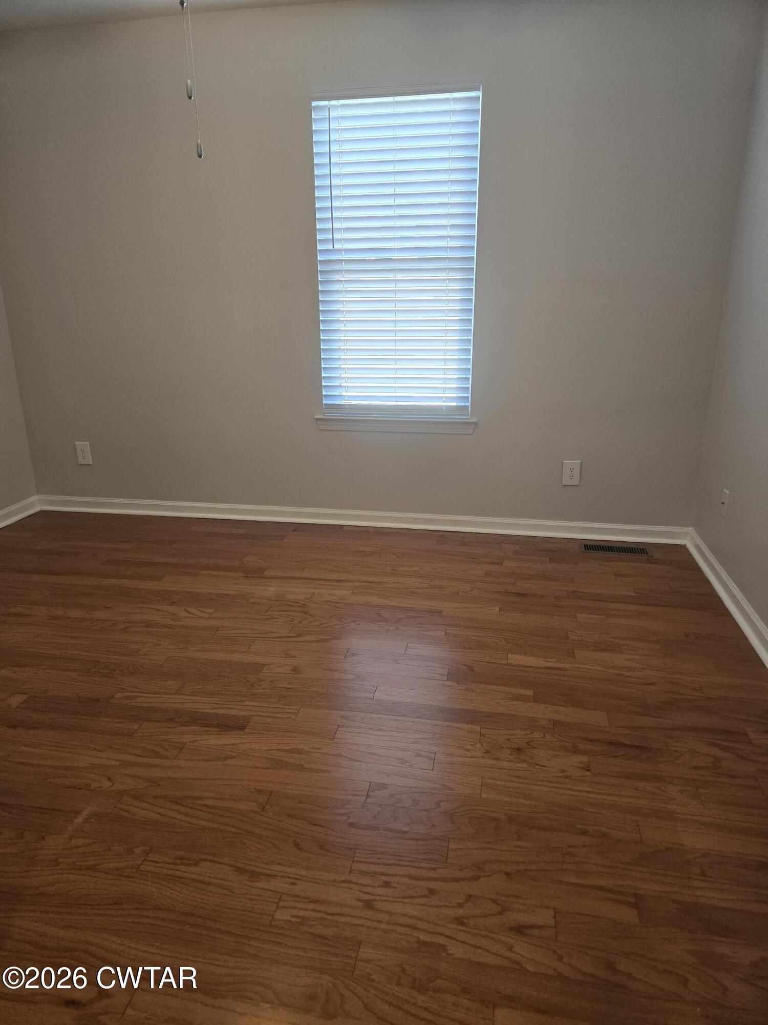 157 Dustin Drive Jackson, TN 38301 - Photo 11 of 22 an empty room with wooden floor and windows