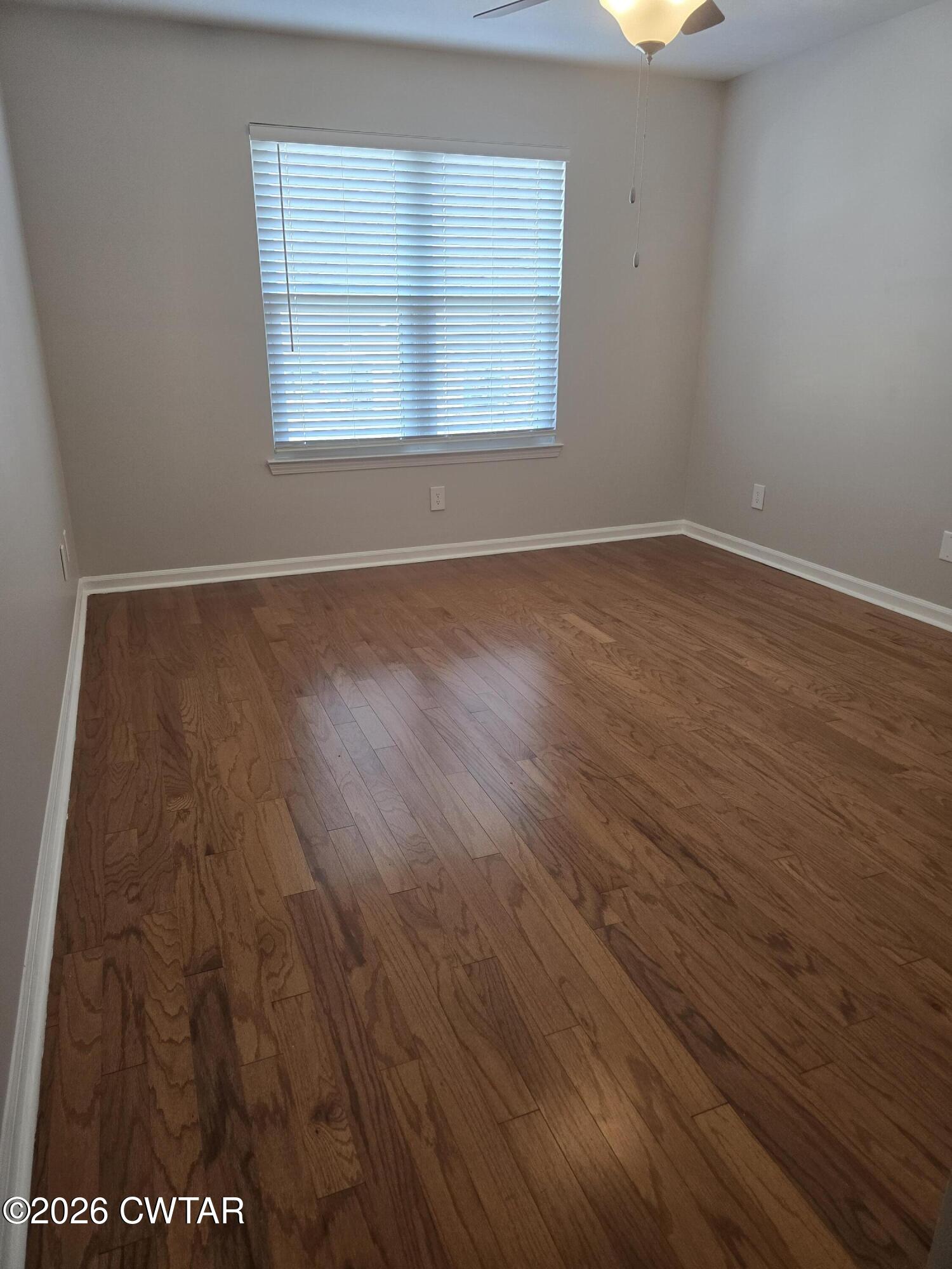 157 Dustin Drive Jackson, TN 38301 - Photo 12 of 22 an empty room with wooden floor and windows