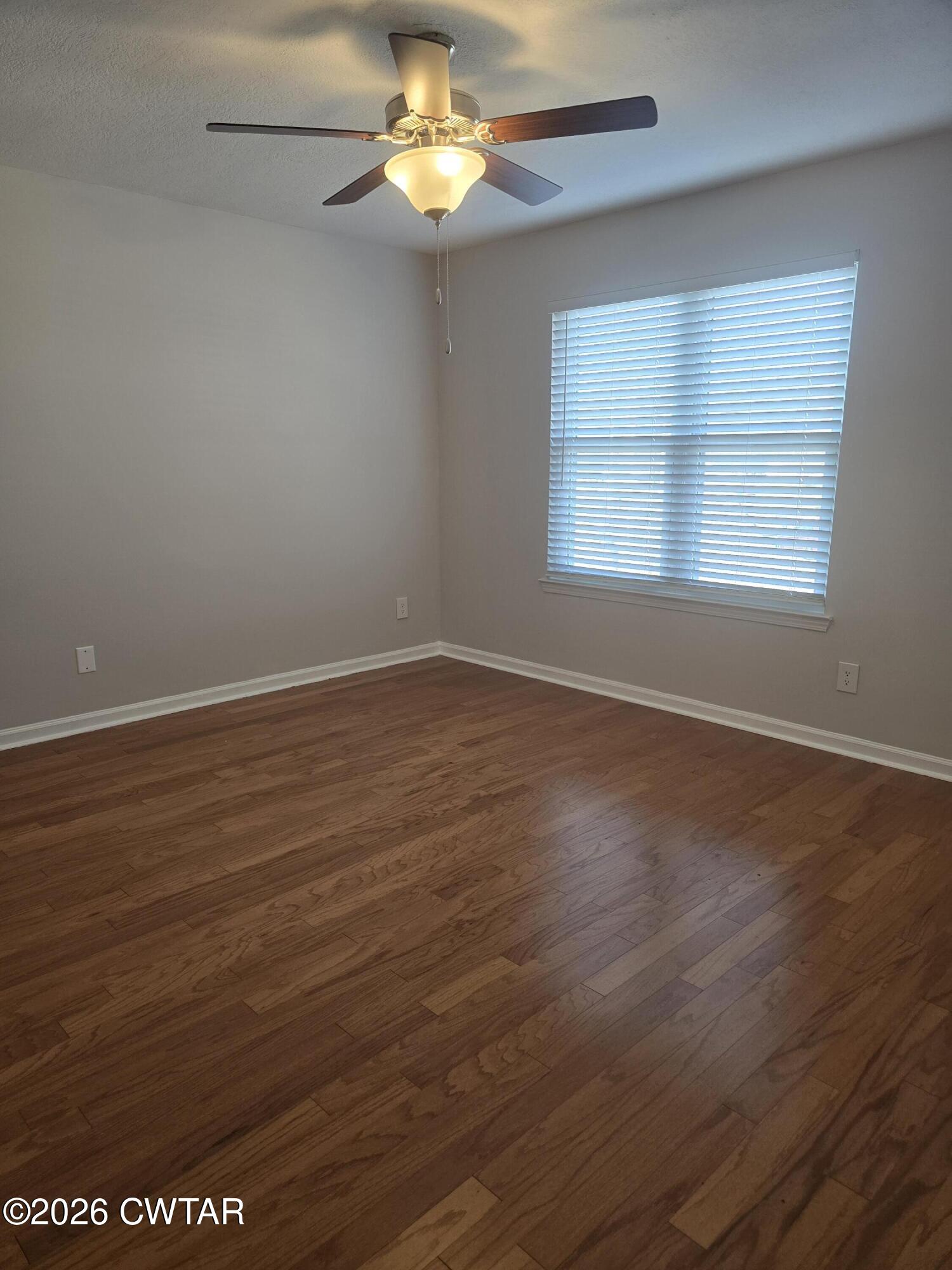 157 Dustin Drive Jackson, TN 38301 - Photo 10 of 22 an empty room with wooden floor and windows