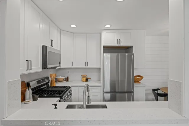 a kitchen with a refrigerator and a stove top oven