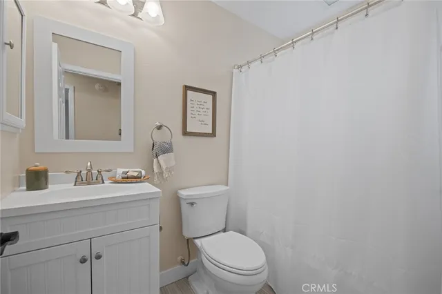 a bathroom with a toilet sink vanity and mirror