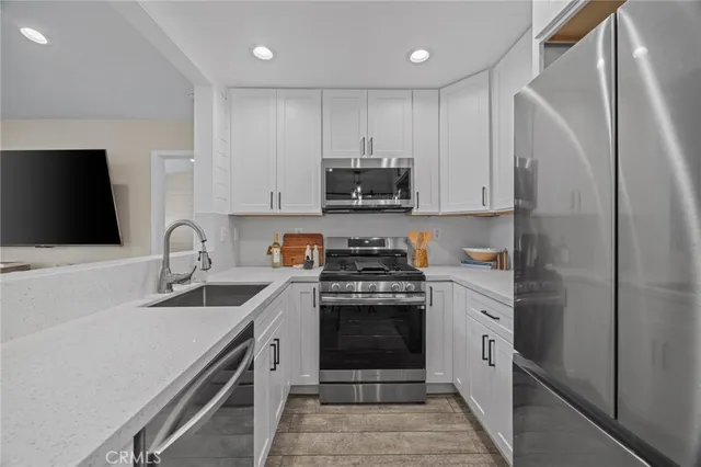 a kitchen with stainless steel appliances granite countertop a stove a sink and a refrigerator