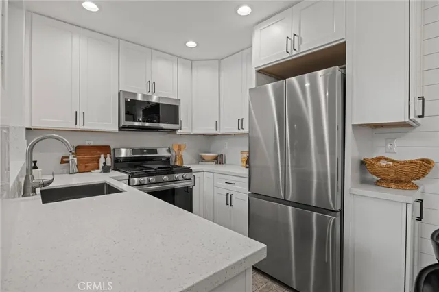 a kitchen with stainless steel appliances a refrigerator sink and microwave
