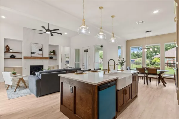 a open kitchen with stainless steel appliances granite countertop a stove a sink a kitchen island with chairs and wooden floor