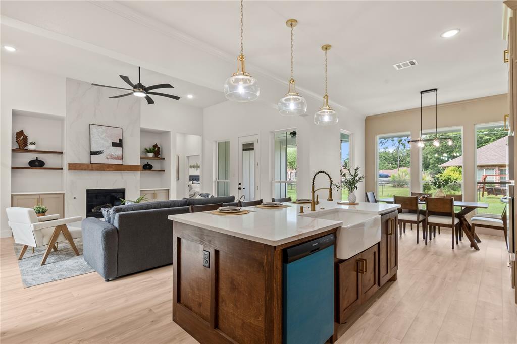 a open kitchen with stainless steel appliances granite countertop a stove a sink a kitchen island with chairs and wooden floor