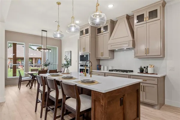 a kitchen with a table chairs microwave and cabinets
