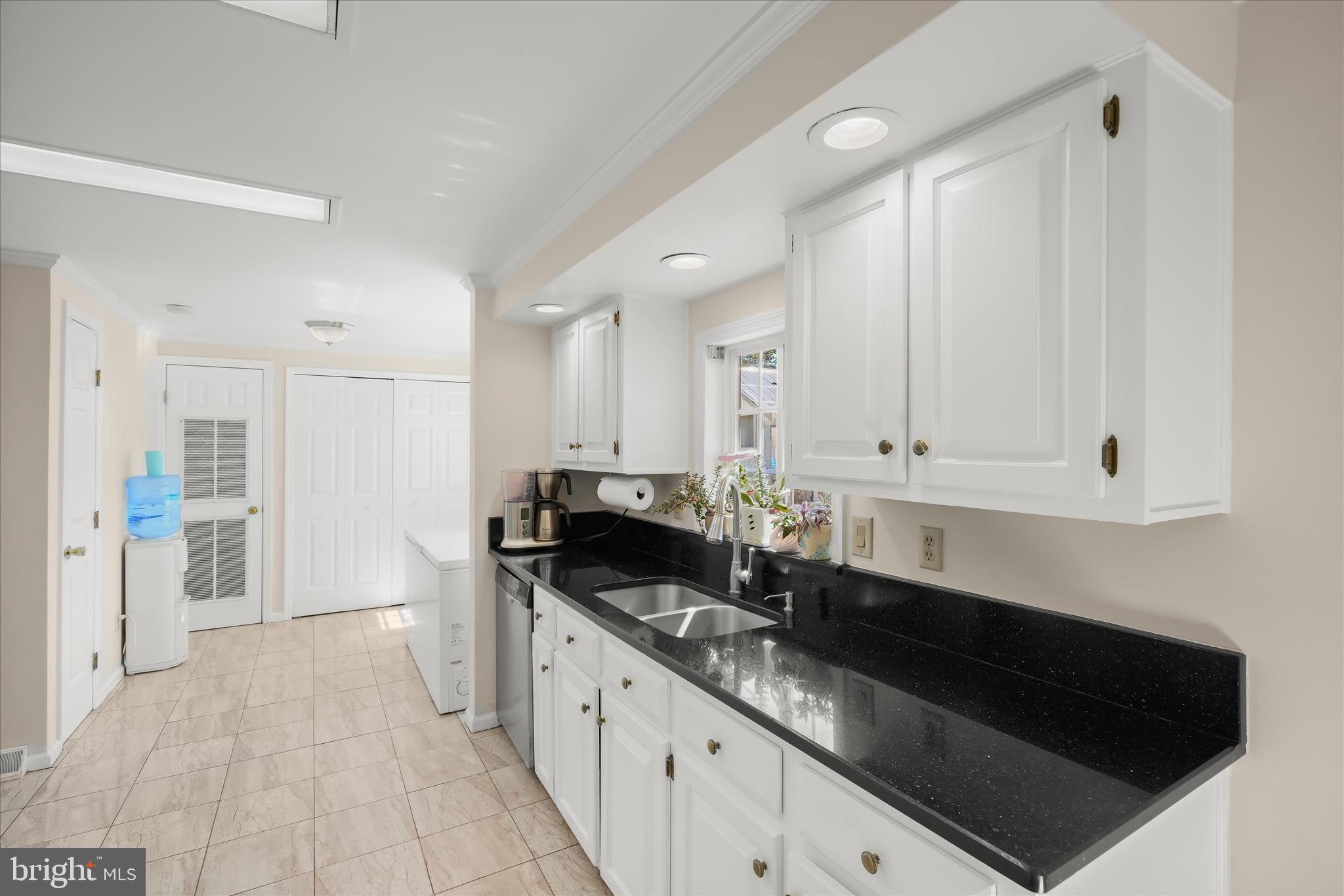 3325 Allday Road Huntingtown, MD 20639 - Photo 18 of 77 a kitchen with granite countertop white cabinets and black appliances