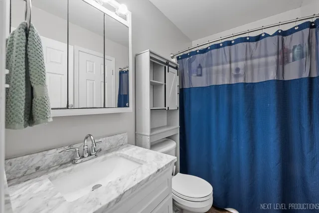 a bathroom with a granite countertop sink toilet and shower