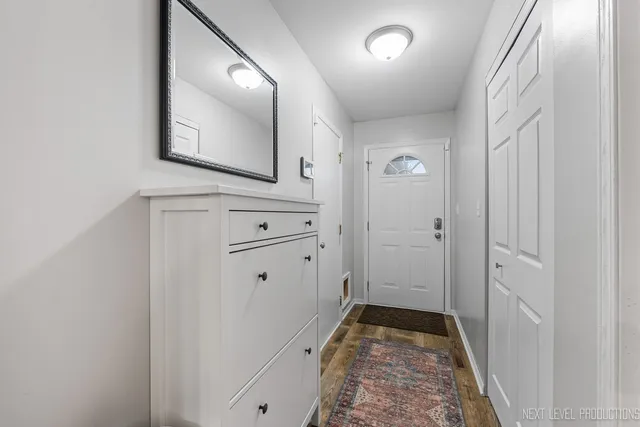a view of a hallway with closet and mirror