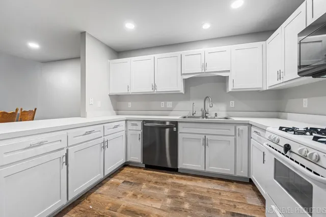 a kitchen with white cabinets stainless steel appliances and sink