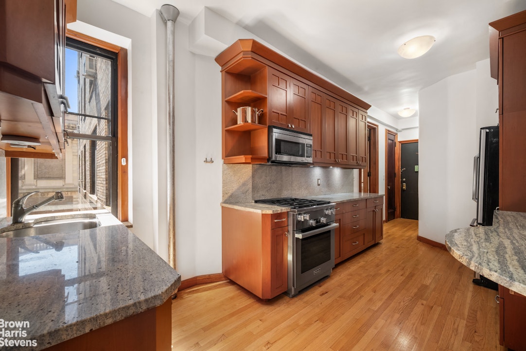 790 Riverside Drive, Unit 4J Manhattan, NY 10032 - Photo 9 of 11 a kitchen with stainless steel appliances granite countertop a stove a sink and a refrigerator