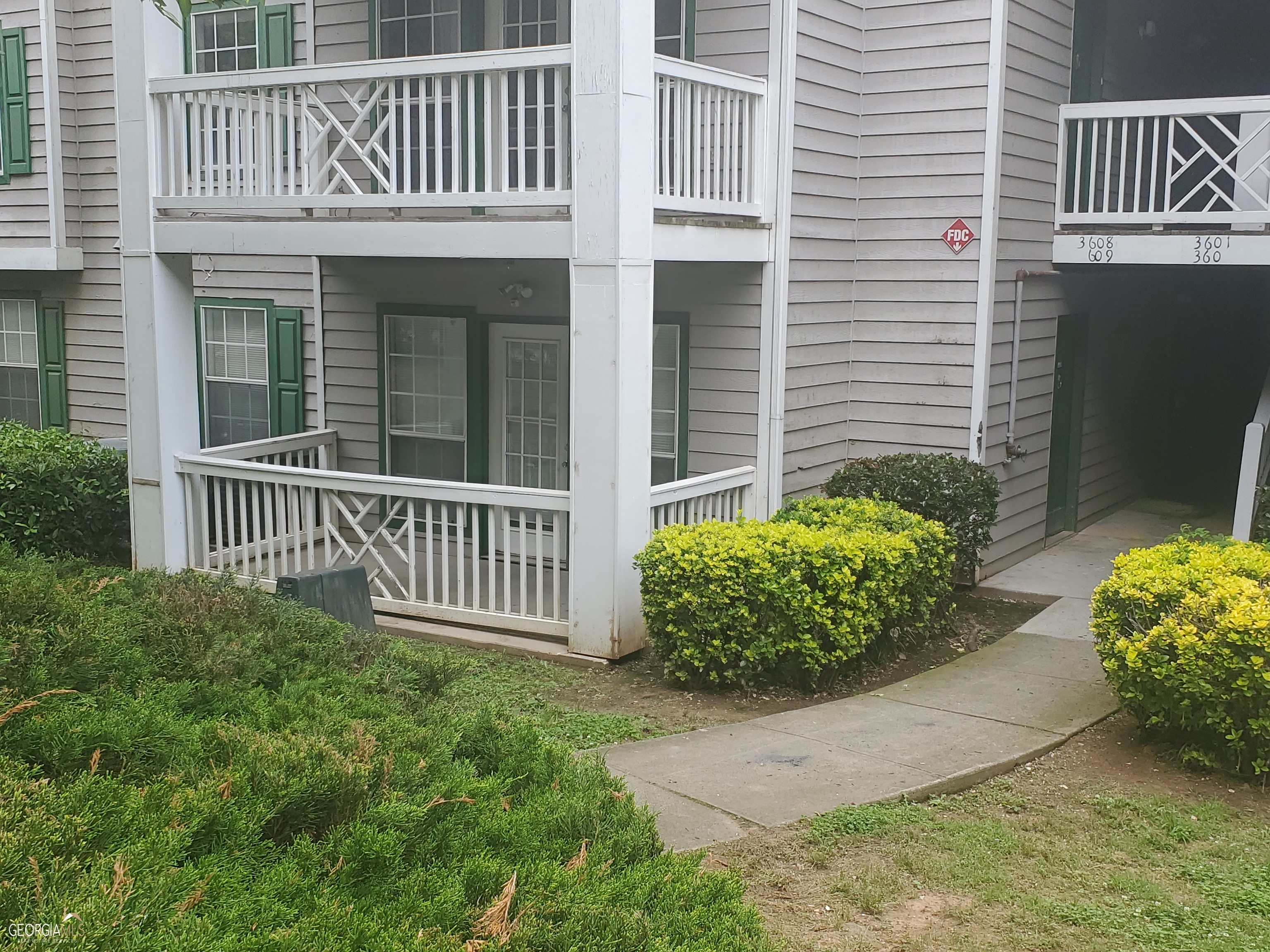 a view of a house with a small yard and flower pot