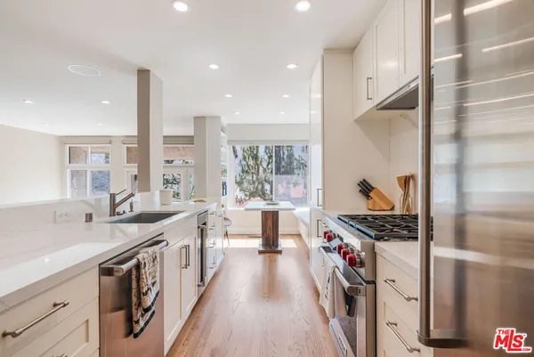 a kitchen with stainless steel appliances a sink stove and cabinets