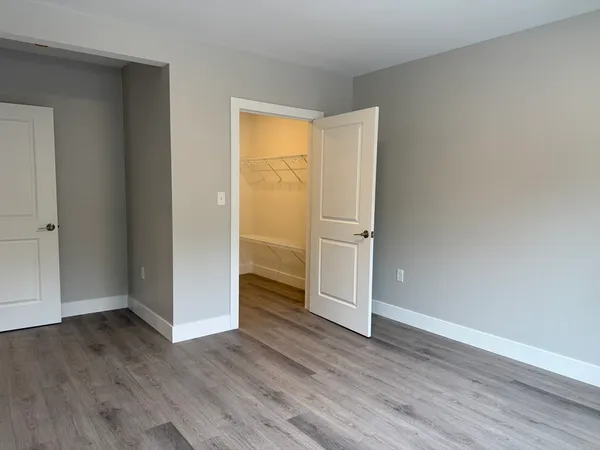 an empty room with wooden floor and closet