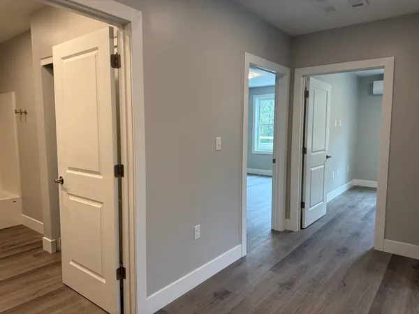 a view of a hallway with wooden floor