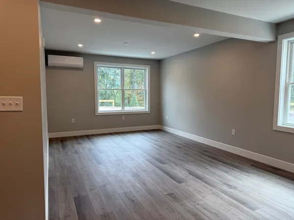 an empty room with wooden floor and windows