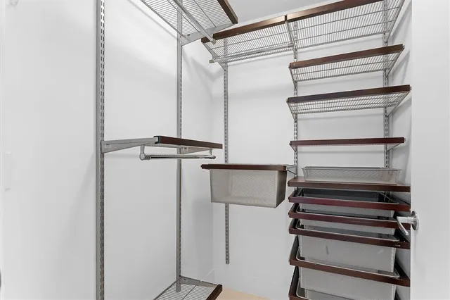 a view of walk in closet with empty racks