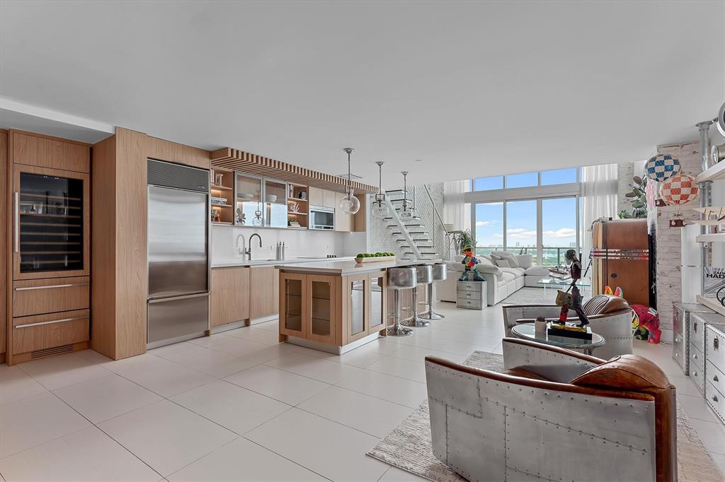 1040 Biscayne Boulevard, Unit 2101 Miami, FL 33132 - Photo 6 of 25 a kitchen with stainless steel appliances kitchen island granite countertop a sink refrigerator and cabinets