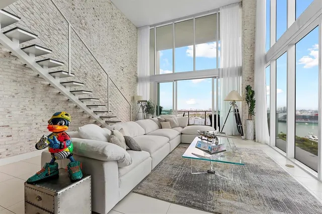 a living room with furniture and a floor to ceiling window