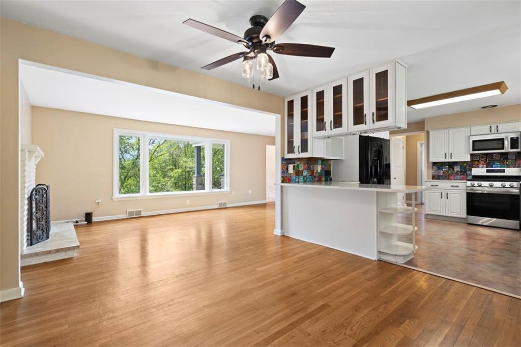 108 W Road Pittsburgh, PA 15209 - Photo 10 of 50 a view of a kitchen with a stove cabinets a ceiling fan and wooden floor