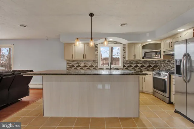a kitchen with stainless steel appliances granite countertop a sink and a refrigerator