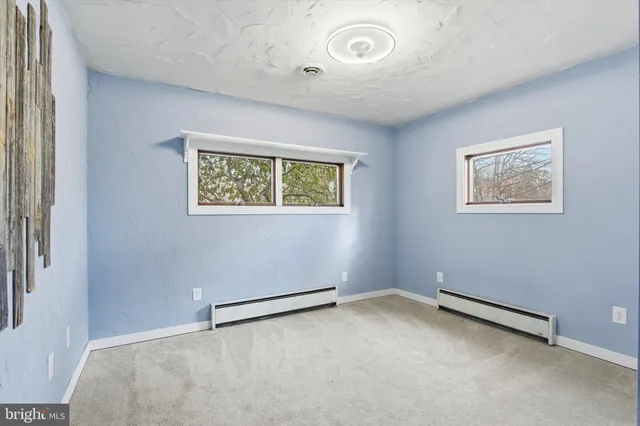 a view of empty room with fireplace and fan