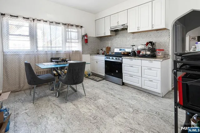 a kitchen with appliances cabinets and chair