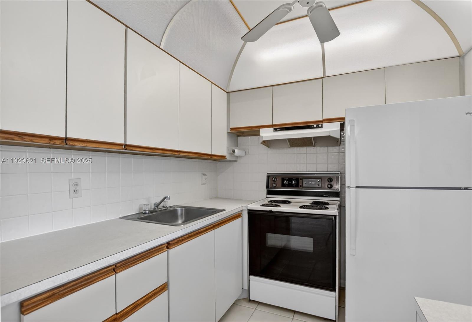 1008 Farnham North, Unit 1008 Deerfield Beach, FL 33442 - Photo 15 of 32 a kitchen with stainless steel appliances a stove a microwave and a refrigerator