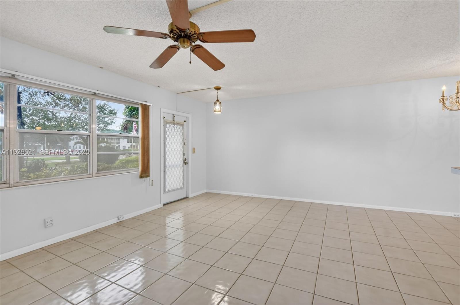 1008 Farnham North, Unit 1008 Deerfield Beach, FL 33442 - Photo 9 of 32 en empty room with windows and ceiling fan
